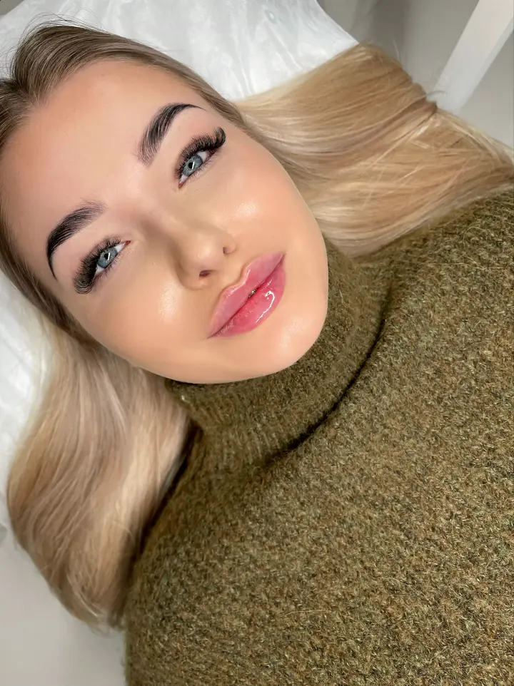 Klientka w oliwkowym swetrze po modelowaniu ust